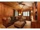 Cozy wood-paneled living room featuring a comfortable leather sofa and a ceiling fan at 4421 Paradise Cir, Vinings, GA 30339