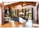 Bright living room with exposed wood beams, stone fireplace, hardwood floors, and large windows at 4421 Paradise Cir, Vinings, GA 30339