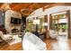 Elegant living room with stone fireplace, wood ceiling beams, hardwood floors, and large windows at 4421 Paradise Cir, Vinings, GA 30339