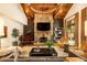 Spacious living room features stone fireplace, wood ceiling beams, and a grand piano at 4421 Paradise Cir, Vinings, GA 30339
