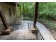 Stone patio featuring dark metal railings, stone pillars, and a lush view of trees at 4421 Paradise Cir, Vinings, GA 30339