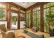 A sun room with floor to ceiling windows features wicker furniture and wood trim at 4421 Paradise Cir, Vinings, GA 30339