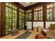 A sun room with floor to ceiling windows features wicker furniture and wood trim at 4421 Paradise Cir, Vinings, GA 30339