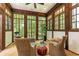 A sun room with floor to ceiling windows features wicker furniture and wood trim at 4421 Paradise Cir, Vinings, GA 30339