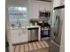 Modern kitchen featuring white cabinets, stainless steel appliances, and stylish striped rug at 5674 Kingsport Dr # 4, Atlanta, GA 30342