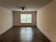 Empty bedroom featuring a ceiling fan, dark floors, and a window providing natural light at 3204 Fairington Village Dr, Lithonia, GA 30038