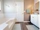Bathroom featuring a tub, white cabinets, wood-look flooring, and coordinated decor at 5175 Bridle Point Pkwy, Snellville, GA 30039