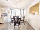 Dining room with modern light fixture, wood table, and large windows for natural light at 5175 Bridle Point Pkwy, Snellville, GA 30039