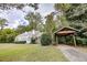 Charming two-story home with blue shutters, dormers, and a covered parking area nestled amongst beautiful trees at 970 E Main St, Canton, GA 30114