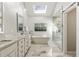Luxurious bathroom with a soaking tub, double vanity, walk-in shower, and skylight at 741 Bentwood Trce, Alpharetta, GA 30005