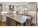 Bright kitchen featuring marble countertops, gray cabinetry, stainless steel appliances and a large island with seating at 741 Bentwood Trce, Alpharetta, GA 30005