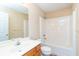 Bright bathroom features a single sink vanity and tub with shower at 1378 Penhurst Dr, Lawrenceville, GA 30043