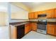 Functional kitchen with wood cabinets, dark countertops, and stainless steel appliances at 1378 Penhurst Dr, Lawrenceville, GA 30043
