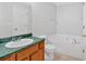 A bathroom with a wood vanity, green countertops, toilet and a garden tub at 1573 Eastern Sunrise Ln, Decatur, GA 30034