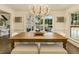 Sunlit dining room with a large table, rustic chandelier, and views of the outdoor patio at 1993 Mount Vernon Pl, Dunwoody, GA 30338