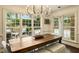 Bright dining area with a rustic table, a modern chandelier and natural light from the windows at 1993 Mount Vernon Pl, Dunwoody, GA 30338