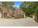 Brick home with a stone facade, patio with seating, mature trees and driveway at 1993 Mount Vernon Pl, Dunwoody, GA 30338