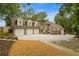 Spacious home featuring a three-car garage, brick accents, and well-maintained landscaping at 1993 Mount Vernon Pl, Dunwoody, GA 30338
