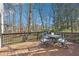 A wood deck with patio table, chairs, grill, and views of the backyard landscape at 325 Upper Creek Ct, Roswell, GA 30076