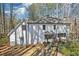 Back of home featuring a stone seating area, a deck, and a two-story white exterior at 325 Upper Creek Ct, Roswell, GA 30076