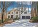 Charming two-story home with a two-car garage, surrounded by mature trees and a concrete driveway at 325 Upper Creek Ct, Roswell, GA 30076