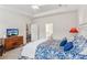 Bright bedroom with blue accents including bedspread and pillows; media dresser with TV at 4645 Dandelion Way, Cumming, GA 30040