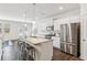 Well-lit kitchen featuring stainless steel appliances, granite countertops, a kitchen island with seating and backyard access at 4645 Dandelion Way, Cumming, GA 30040