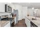 Close up of a kitchen, featuring stainless steel appliances, granite countertops, and white cabinets at 4645 Dandelion Way, Cumming, GA 30040