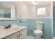 Vintage bathroom featuring a light blue tile surround, a toilet, and a modern white sink at 1337 M L King Jr Nw Dr, Atlanta, GA 30314
