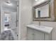 Bathroom with large mirror, open doorway, and sleek vanity at 2075 Pine Tree Dr, Buford, GA 30518