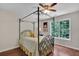 Cozy bedroom with a four-poster bed, hardwood floors, and a window at 2075 Pine Tree Dr, Buford, GA 30518