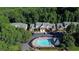 Overhead shot of a community pool with lounge chairs surrounded by lush landscaping, near townhome buildings at 2075 Pine Tree Dr, Buford, GA 30518