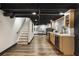 Finished basement with wood-look flooring, stairs, and kitchenette with light wood cabinets at 330 Chaffin Ridge Ct, Roswell, GA 30075