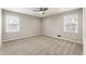 Neutral bedroom featuring plush carpet, ceiling fan, and dual windows for optimal natural light at 330 Chaffin Ridge Ct, Roswell, GA 30075