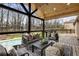 Inviting covered deck with a seating area, stylish furniture, ceiling fan, and views of the lush backyard and sparkling pool at 330 Chaffin Ridge Ct, Roswell, GA 30075