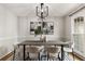 Elegant dining room with modern light fixture, stylish artwork, and a large window for ample natural light at 330 Chaffin Ridge Ct, Roswell, GA 30075