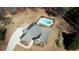 An aerial view showcases the house with a pool in the backyard, a driveway, and nearby mature trees at 75 Horseshoe Dr, Covington, GA 30014