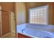Bathroom features a large soaking tub, glass block window, and a glass enclosed shower at 75 Horseshoe Dr, Covington, GA 30014