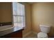 Bright bathroom featuring a toilet, vanity, and large window with natural light at 75 Horseshoe Dr, Covington, GA 30014