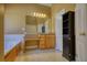Bathroom with a large tub, vanity, and mirror, and a decorative cabinet at 75 Horseshoe Dr, Covington, GA 30014
