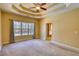 Bedroom features tray ceiling, large window with natural light, neutral carpeting, and yellow walls at 75 Horseshoe Dr, Covington, GA 30014
