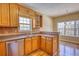 Well-lit kitchen with wood cabinets, stainless steel dishwasher, decorative backsplash, and a window over the sink at 75 Horseshoe Dr, Covington, GA 30014