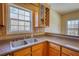 Kitchen featuring a stainless steel sink, wood cabinets, tile backsplash, and view to the breakfast nook at 75 Horseshoe Dr, Covington, GA 30014