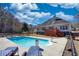 A fenced in backyard features a pool, patio with lounge chairs, and a deck off the back of the house at 75 Horseshoe Dr, Covington, GA 30014