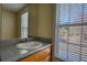 Bathroom vanity with a granite countertop, a mirror, and a bright window at 75 Horseshoe Dr, Covington, GA 30014