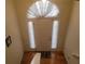 Elegant entryway with wood floors, white door, and arch window adorned with curtains at 903 Tucker Ln, Loganville, GA 30052