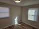 A sunlit bedroom boasts wood floors and two windows with blinds for natural light at 938 Rebel Forest Se Dr, Atlanta, GA 30315