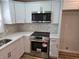 Updated kitchen with stainless steel appliances, white cabinetry and hexagon backsplash at 938 Rebel Forest Se Dr, Atlanta, GA 30315