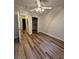 Neutral bedroom with wood-look flooring, ceiling fan, open doors to closet and adjacent room at 1965 Nocturne Dr # 1103, Alpharetta, GA 30009