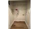 Compact laundry closet with overhead wire shelving and hookups, featuring durable wood-look flooring at 1965 Nocturne Dr # 1103, Alpharetta, GA 30009